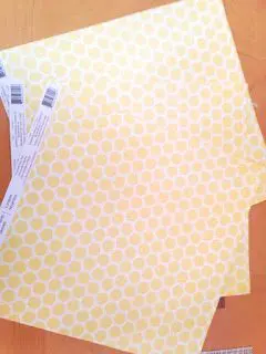 Three pages of scarpbooking paper in a 12 by 12 square. The paper is white with yellow hexagons. 