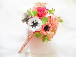 A lovely, cheerful bouquet of paper flowers wrapped with a ribbon handle is perfect for weddings or other events. 