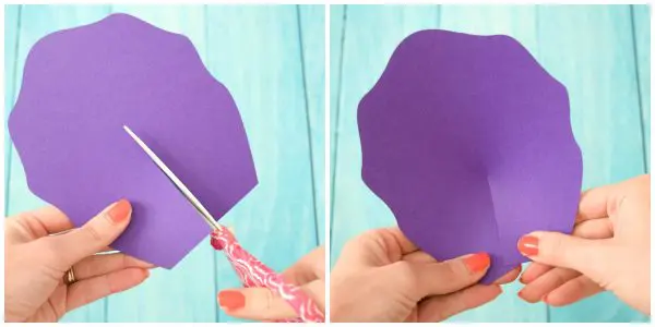 DIY Iris Unicorn Rainbow Flowers instructions for large rainbow paper flowers. Abbi Kirsten's hand shows how to cut a slit on a large purple petal and then how to shape the petal.