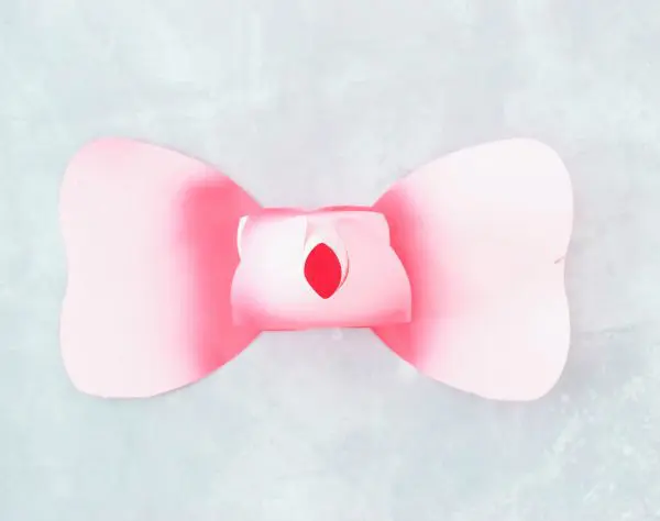 Step 2 in making the paper rose center has added a petal wrapped around the center of the petal bowtie. 