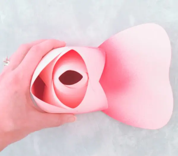 The left side of the rose center is glued to the bud, while the right side petal is flat. It will be wrapped and glued to the rosebud next. 