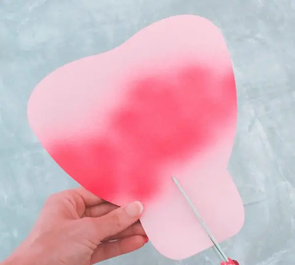 Abbi cuts slits into the bottom of all the remaining large pink paper petals. This will aid in attaching to the base of the bud.