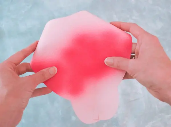 The sides of the giant Alora paper rose flower are curled and glued inward.