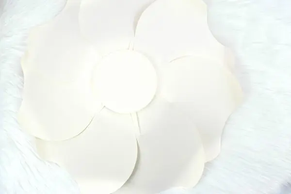 Large paper petals arranged in a circle form the bottom layer of a paper Bella Rose. 