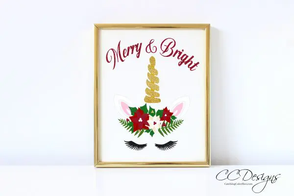 FREE Reindeer Cut File & Poinsettia Template can be altered to include a golden horn and unicorn ears. The text is above the image in red script and reads "Merry and Bright." The picture is in a gold frame. 