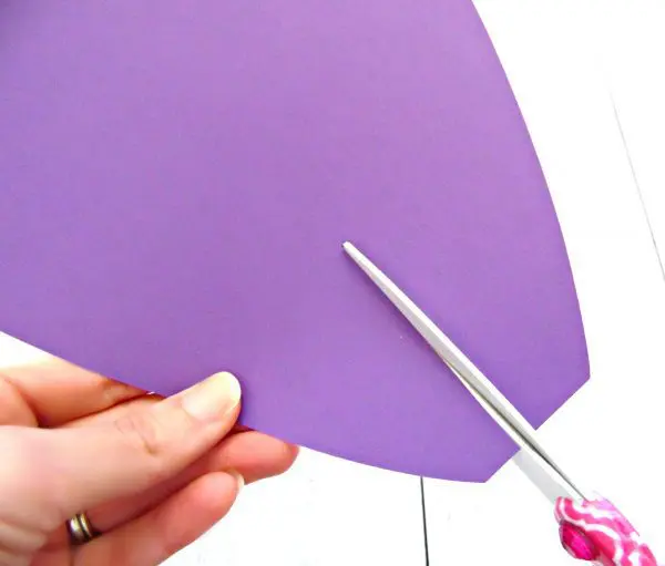 Abbi Kirsten uses scissors to cut a slit in the bottom of the purple paper petals. These slits allow the petals to curl easier so your giant flowers can bloom.