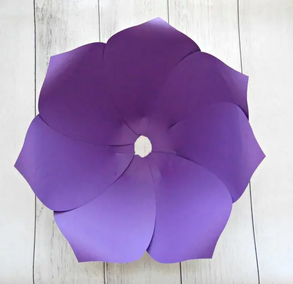 Seven giant purple paper petals are glued together to form a circular outer layer of a giant paper flower. The petals were cut using an Abbi Kirsten template and SVG files for a Cricut cutting machine.