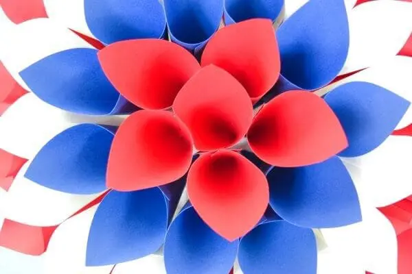 The final layer of cones is six red cones in the center of the paper dahlia wreath. It's surrounded by a blue layer, white layer, and red layer moving outwards.