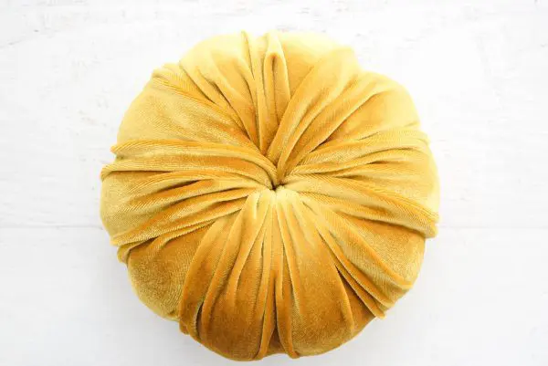 The pumpkin is fully covered with gold velvet fabric, tucked neatly into the stem hole, creating a no-sew velvet-covered pumpkin.