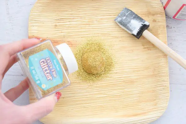 Generously sprinkle extra-fine gold craft glitter onto the pumpkin stem that has been previously covered in Mod Podge.