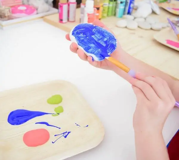 A rock being painted a bright blue.