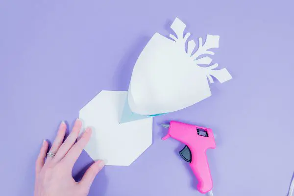 Abbi demonstrates how to glue the snowflake petals to the 8-sided base.