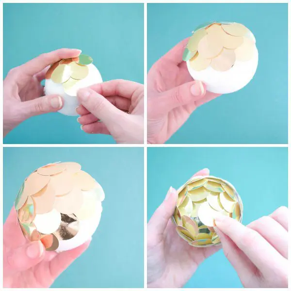 A grid of four photos showing steps 5, 6, 7, and 8. The first photo shows Abbi layering the gold circles on the foam ball. The second photo shows the foam ball half covered in golf circles. The third photo displays how each layer of golf circles is tucked under the layer above it. The fourth photo shows Abbi adding the final gold circle. Kid friendly DIY Christmas ornaments to deck your halls this holiday season!