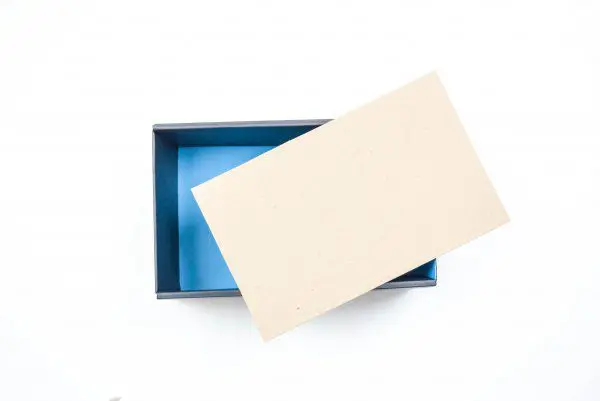An overhead view of a cardboard box with a chip board laying over the opening. You can make this box inspire joy by wrapping it in stretchable velvet.