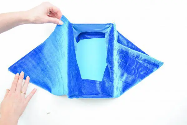 Abbi's hands gently fold the velvet fabric on the outside to conceal the edges.
