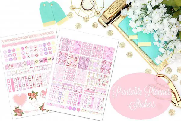 An overhead view of two sheets of pink February Planner stickers surrounded by teal and gold tags and office supplies. The pink circle has white text that says "printable planner stickers" in a script font.