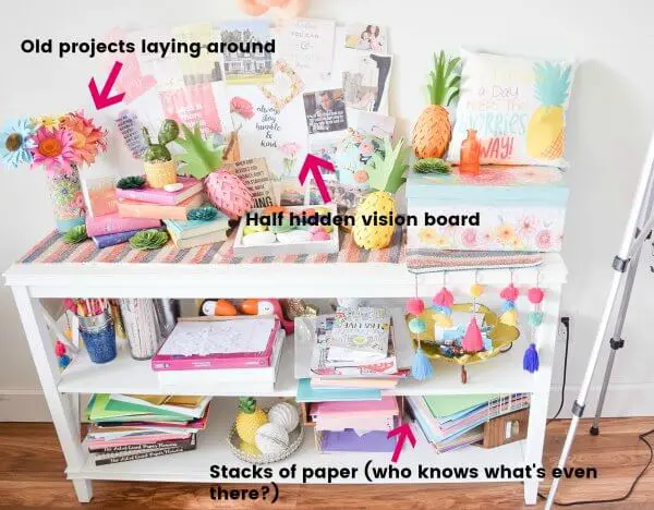 A “before” photo of a craft room shelving unit crammed with random stacks of craft paper and old projects. You can learn to organize your craft room.