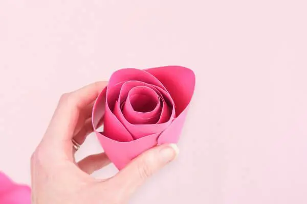 Abbi holds a large finished rosebud center. Making paper flowers, like these Penelope roses, can be fun and easy when using these picture instructions.