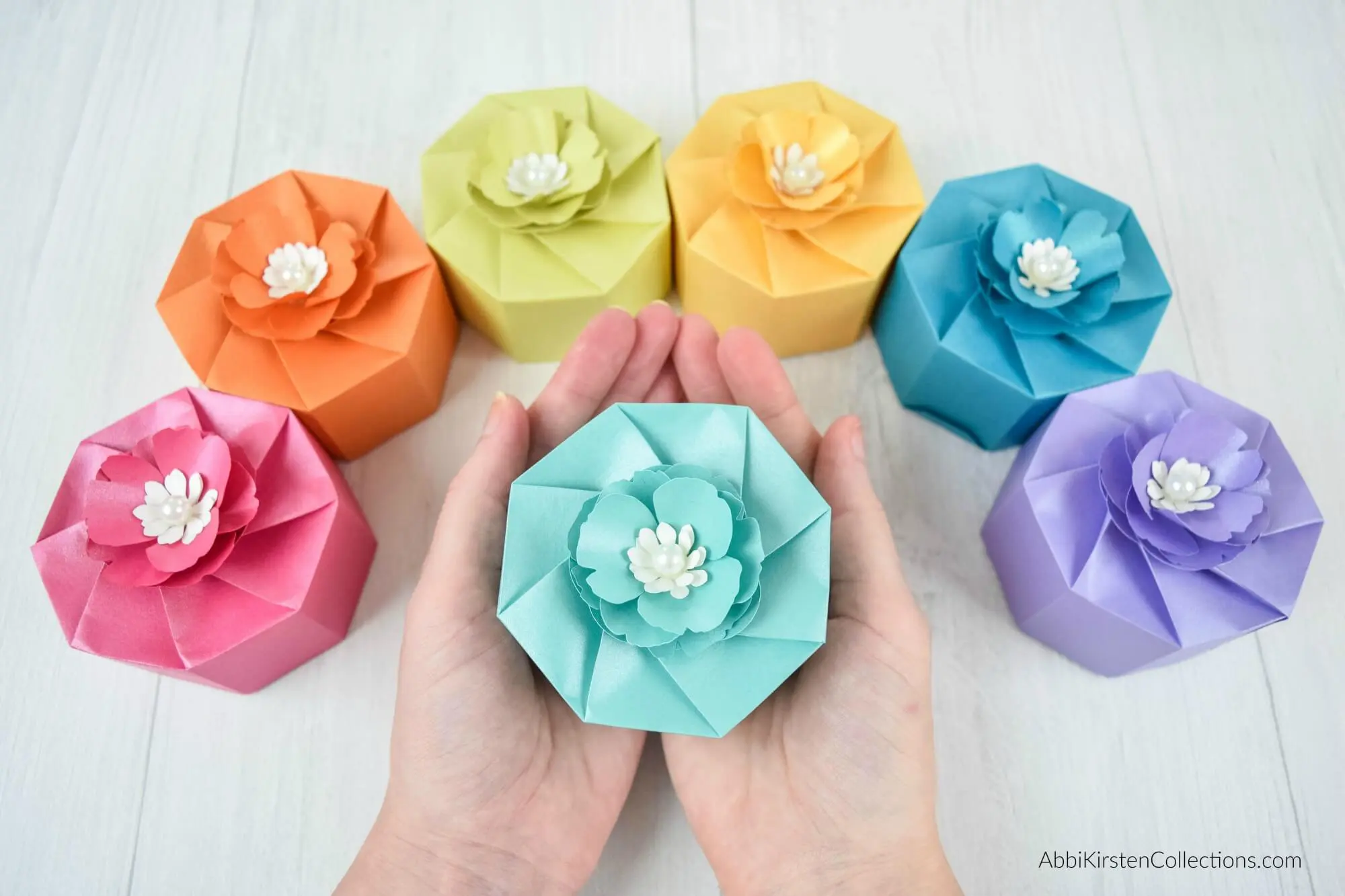 hands holding a light blue paper box