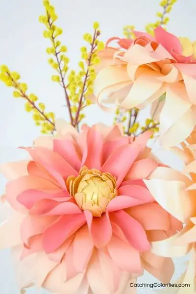 A beautiful display of autumn sunburst dahlia paper flowers in shades of pink and light orange.