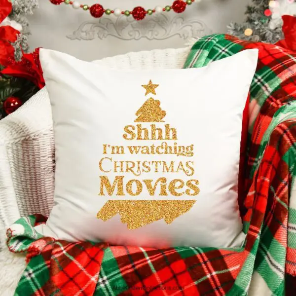 The images show a White Christmas pillow throw pillow on a red and green plaid blanket. The pillow has a gold vinyl graphic that says, "Shh I'm watching Christmas movies."