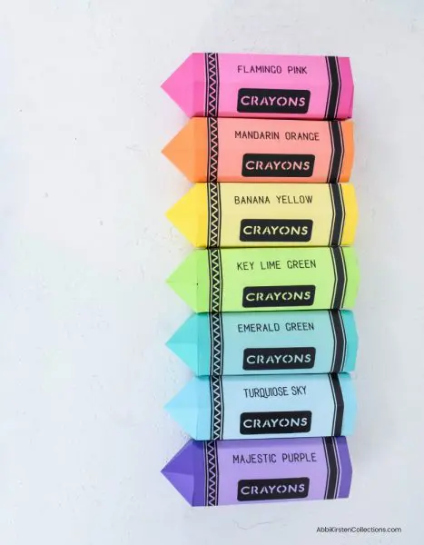 A birds-eye view of paper crayon gift boxes lined up in rainbow formation. If you are looking for the perfect teacher appreciation gift, get your free template here.