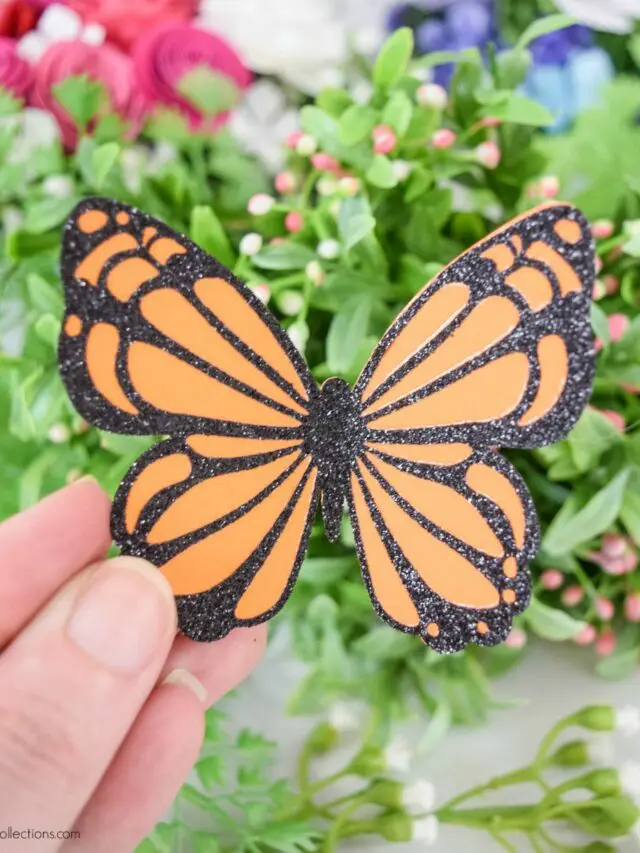 A hand holding a paper butterfly.
