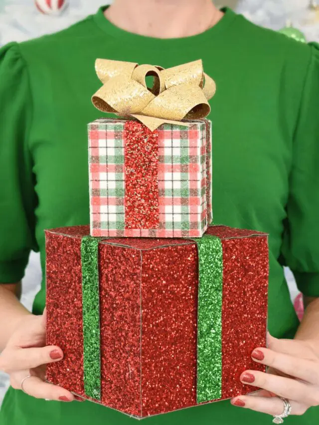 A woman wearing a green puff sleeved shirt while holding two Decorative Christmas Gift Boxes stacked on top of each other