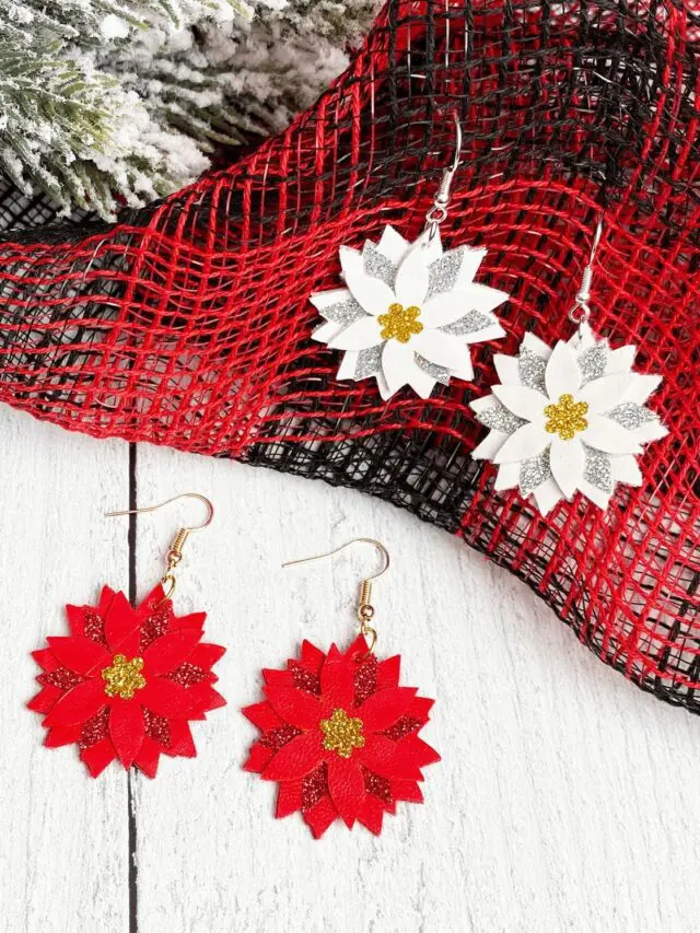 Two pairs of Christmas Poinsettia, a red pair and a white pair on a wooden surface