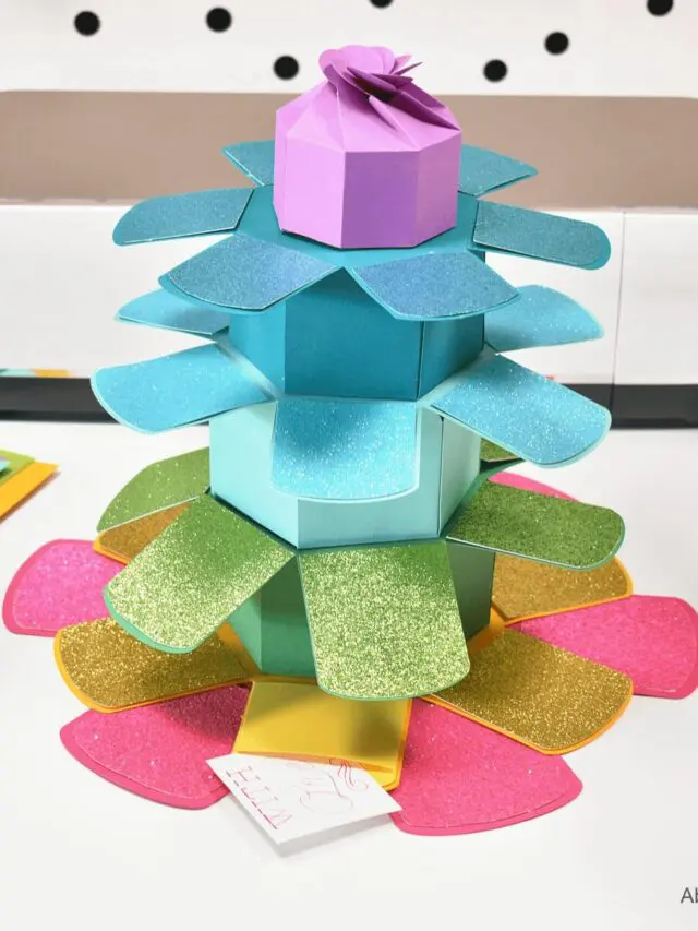 An Explosion Stacking Tower Gift Box on a white surface surrounded by craft supplies