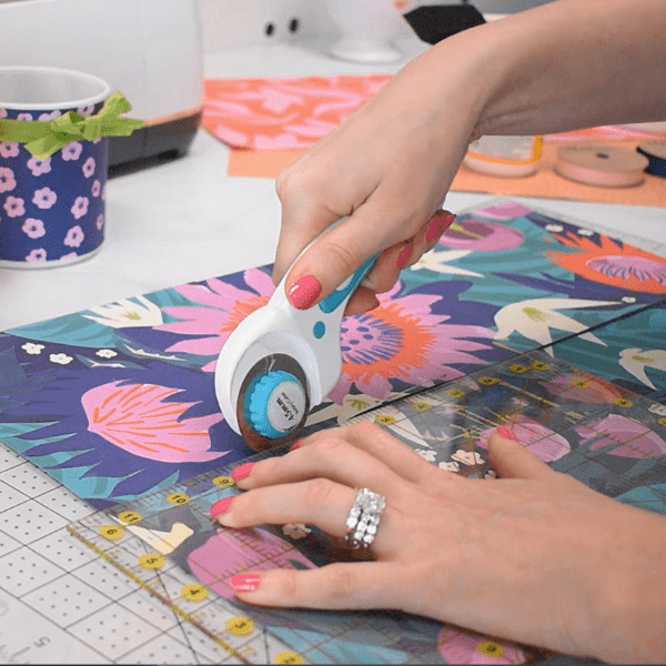 Trimming brightly colored wrapping paper. 