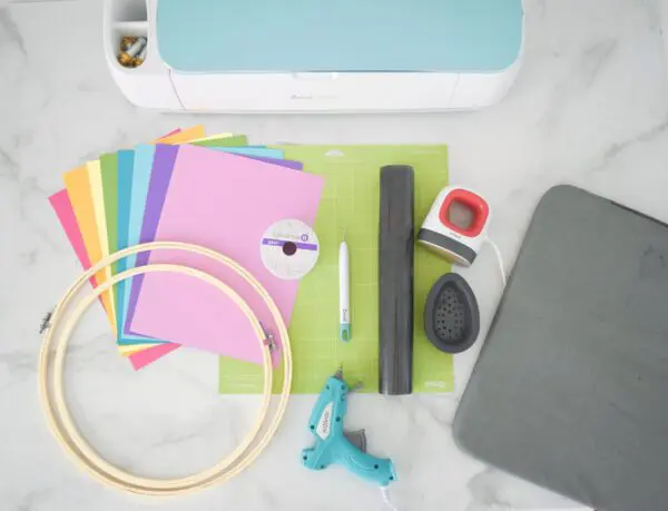 All the supplies needed to make paper butterflies - cardstock, embroidery hoops, a glue gun, the EasyPress Mini, and a cutting machine.