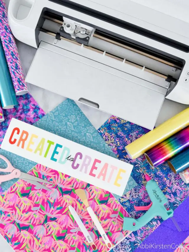 Cricut machine on a desk with crafting materials.