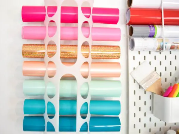 A picture of an Ikea plastic bag holder for vinyl, hung on the wall. These racks are available to help organize your Cricut vinyl.