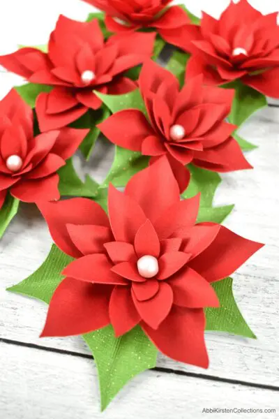 Small poinsettia paper flowers. Download poinsettia flower templates to create an easy paper craft for your Christmas holiday decor.