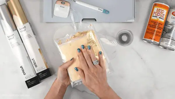 All the supplies needed to make gold gilded acrylic ornaments using a Cricut machine. Smart vinyl, gold leave sheets, mod podge, and your Cricut maker.