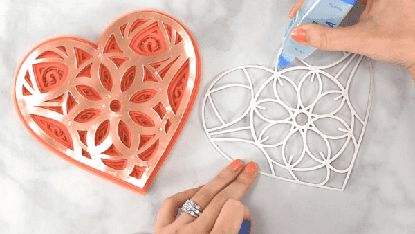 Glue being applied to one layer of a heart mandala.