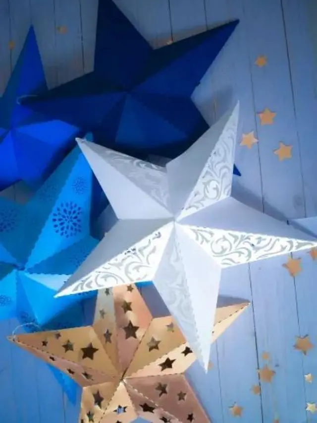 Three 3D paper stars in dark blue, blue and white.