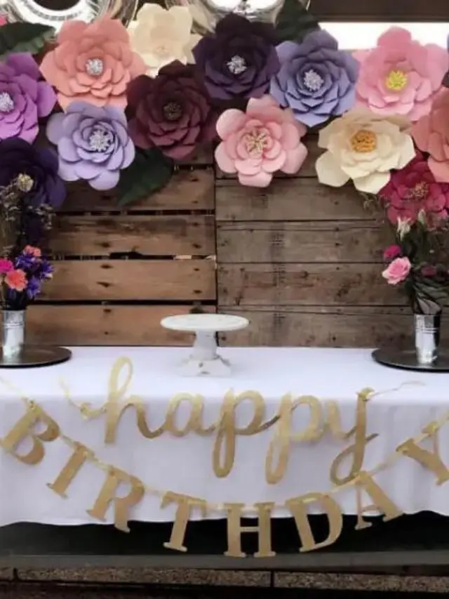 Giant paper flowers as a backdrop for a birthday celebration