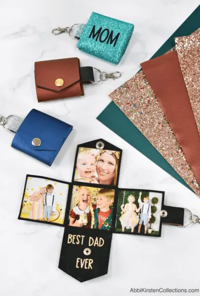 Multiple DIY faux leather photo keychains in different colors and with varying text next to colorful sheets of faux leather.