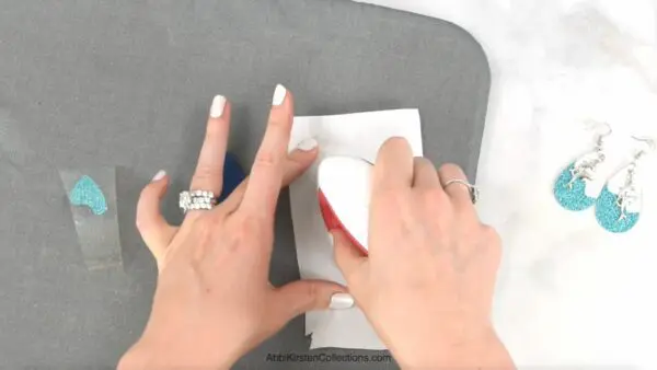 An EasyPress Mini pressing pieces of faux leather together on a grey mat. 