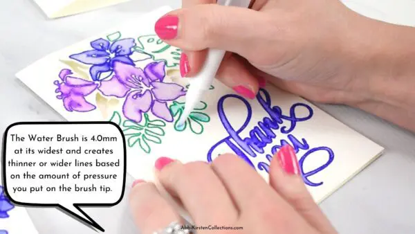 A close-up of Abbi coloring in a green leaf. The speech bubble says "The Water Brush is 4.0mm at it's widest and creates thinner or wider lines based on the amount of pressure you put on the brush tip."