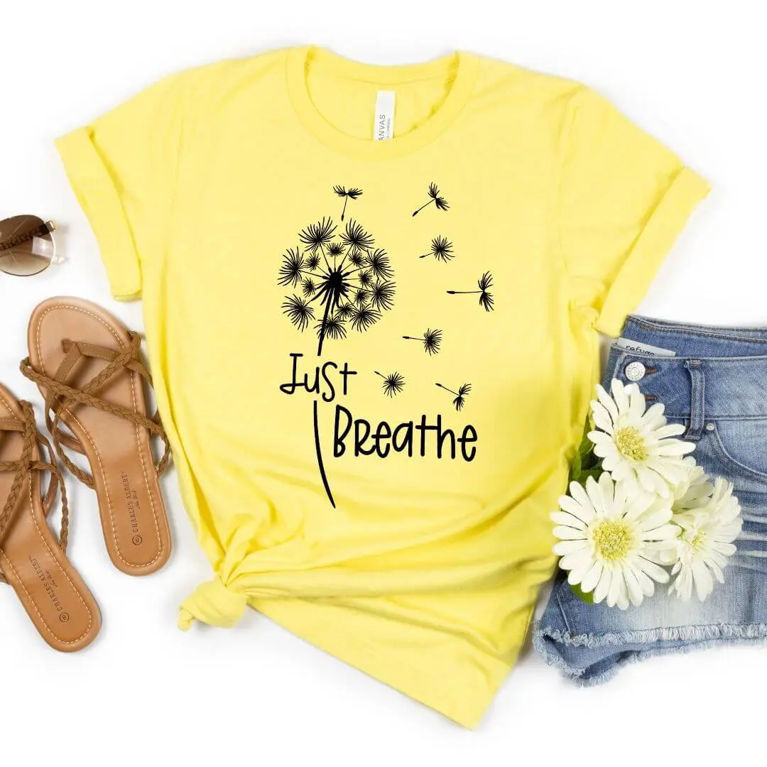 A yellow t-shirt mockup with a design that says "Just Breathe"
