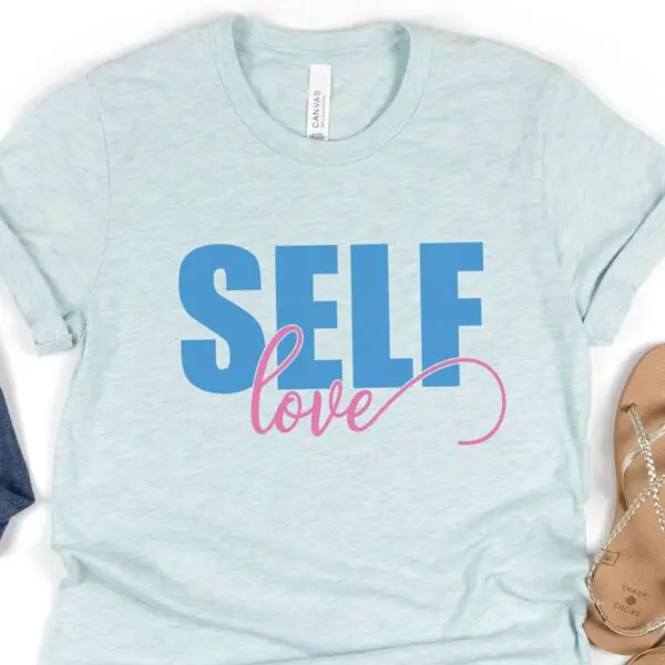 A light blue t-shirt has a graphic on it that reads "Self Love." This SVG file is free to use.