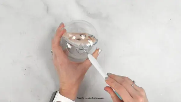 Weeding tool being used to adjust photo inside ornament