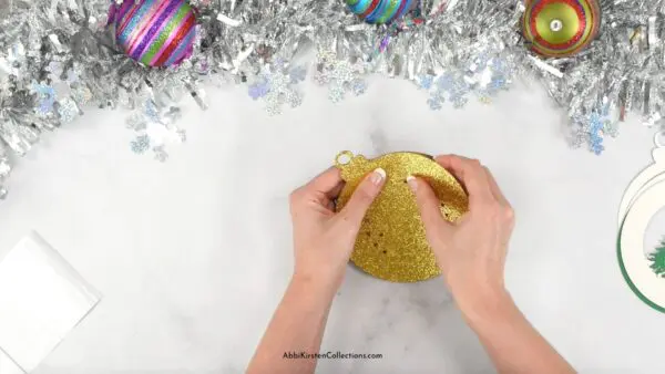 Layering gold glitter cardstock paper craft.