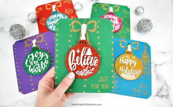 Glitter ornaments with acrylic disks. Make cardstock display cards for gifting ornaments. Free SVG cut files for Cricut Design Space.