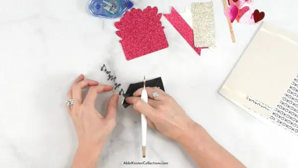 Abbi Kirsten's hands weed iron-on vinyl for a Valentine's Day card made with Cricut.