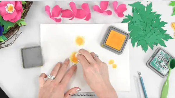 The image shows how to add distress ink to paper flower petals.