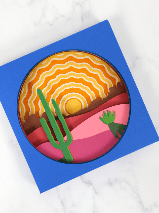 Layered shadow box paper craft made with Cricut. The scene is of a sunrise in the desert.